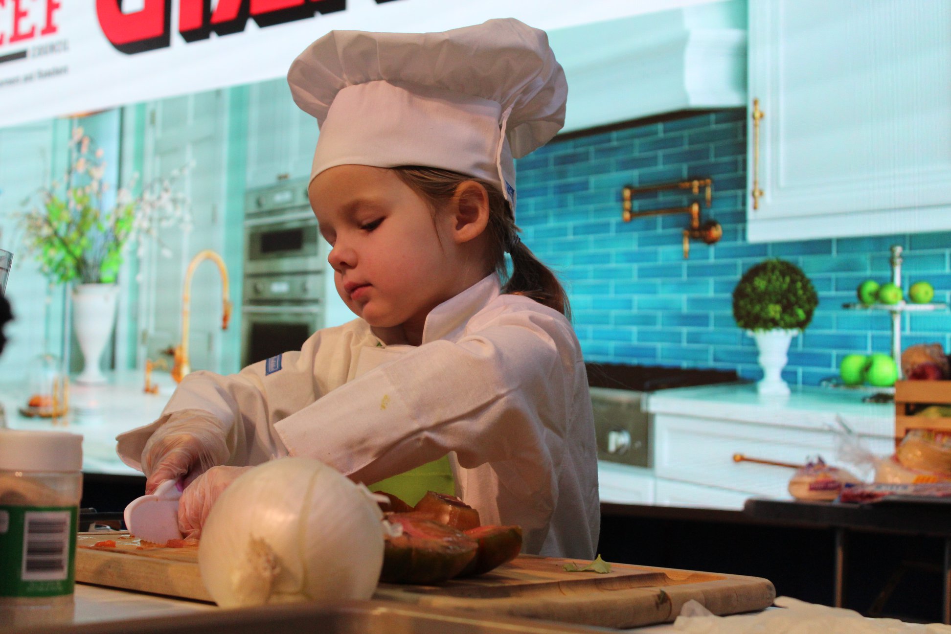 A young girl dressed as a chef and cooking at the 2020 Pennsylvania Farm Show.